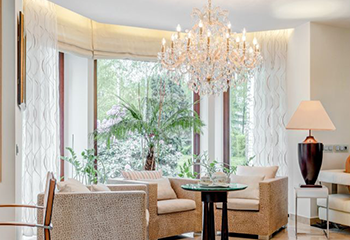 A luxurious living space adorned with taupe window shades and sheer curtains.